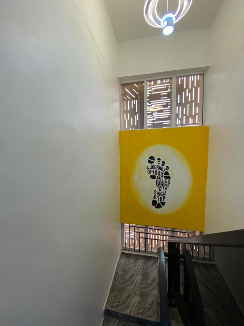 The iconic footprint mural: 'A journey of 1000 miles begins with a single step'.